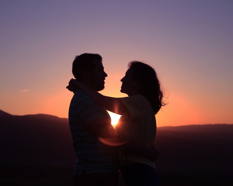 Couple enlacé devant un couché de soleil