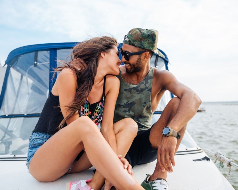 pareja en un barco al atardecer en actitud cariñosa