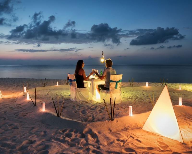 pareja durante una cena romántica en la playa
