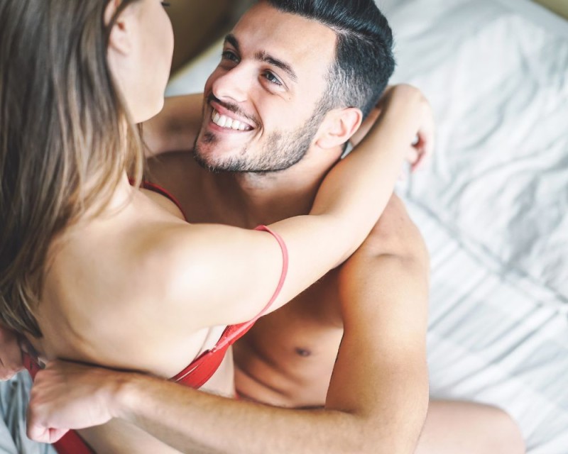 couple in bed with him smiling at her