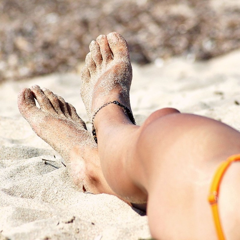Close up of a woman's legs and feet on the beach