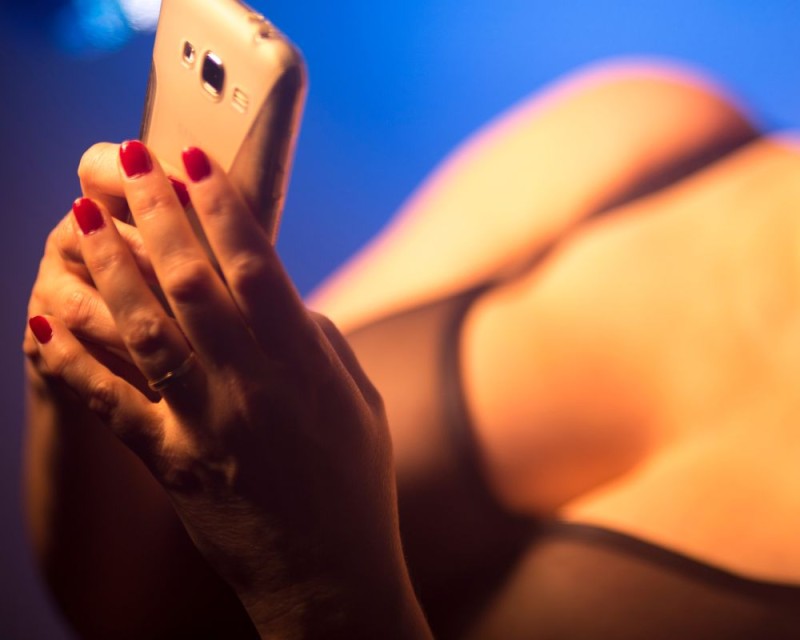 mujer en ropa interior envía un mensaje con su teléfono