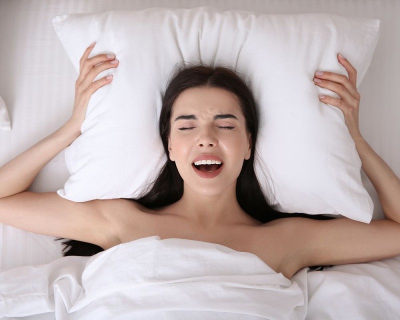 mujer alcanza el orgasmo en la cama